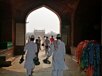 Group of people walking in front of historical building