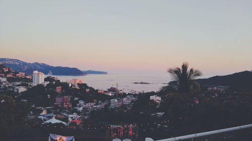 Scenic view of sea and buildings against sky during sunset