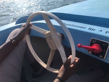 Close-up of man driving boat in sea