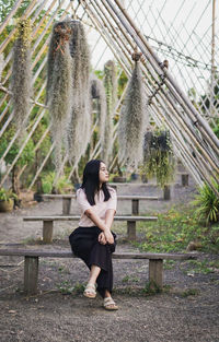 Rear view of woman sitting on bench