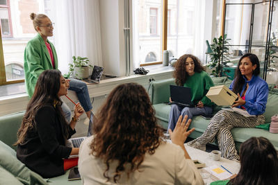 Businesswomen discussing with each other during meeting at workplace