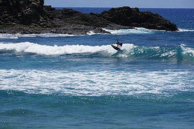 Man surfing in sea against sky