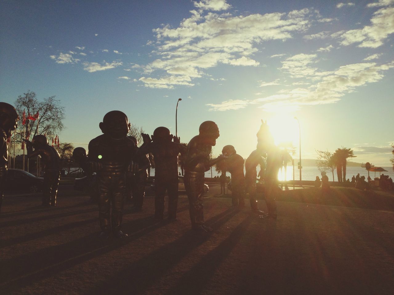 silhouette, sunset, sky, men, large group of people, lifestyles, person, leisure activity, sun, sunlight, medium group of people, togetherness, cloud - sky, sunbeam, tree, mixed age range, transportation, cloud, group of people