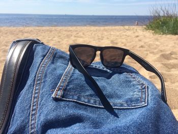 Close-up of sunglasses on beach