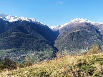 Scenic view of snowcapped mountains against blue sky