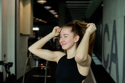 Portrait of young woman with arms raised