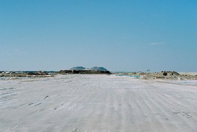 Scenic view of beach against clear blue sky