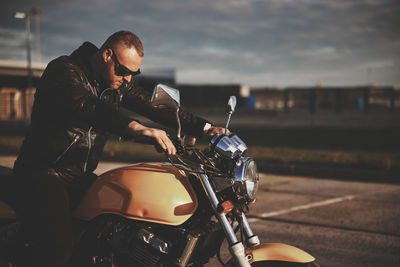 Side view of man riding motor bike on street