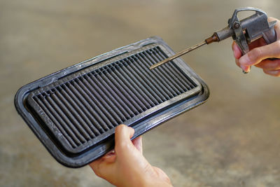 Cropped hand cleaning air filter at workshop