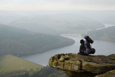 Rear view of man looking at mountains against sky