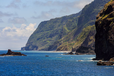 Scenic view of sea and mountains against sky