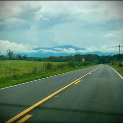 Road passing through land against sky