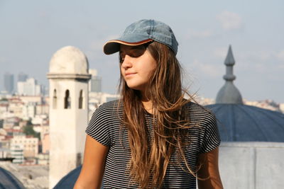 Portrait of young girl  standing against buildings in istanbul