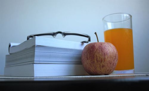 Close-up of apple and books on table