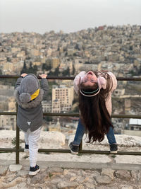 Rear view of woman standing on footpath