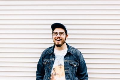 Happy man standing against wall