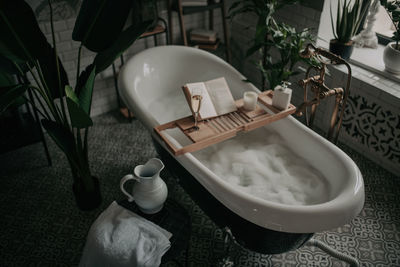 Luxury interior of big bathroom at modern african style with oval bathtub in natural lighting