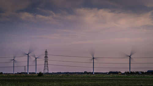 Electricity pylon on field against sky during sunset