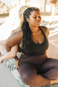 Woman doing exercise with female friend at retreat center