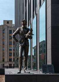 Statue against modern buildings in city