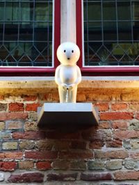 Close-up of stuffed toy against brick wall