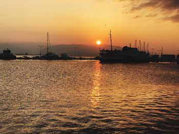 Boats sailing in sea against sky during sunset