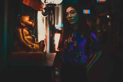 Portrait of young woman standing outdoors at night