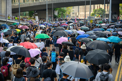 Group of people walking on wet street in city