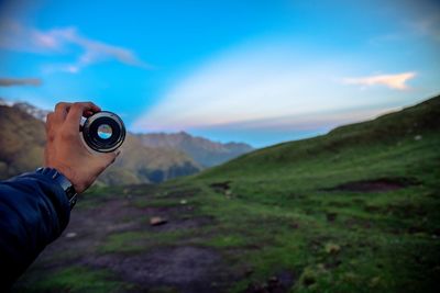 Man photographing mountains against sky
