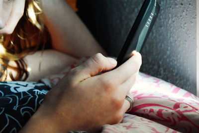 Low section of woman relaxing on bed