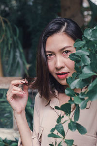 Portrait of a young woman holding plant