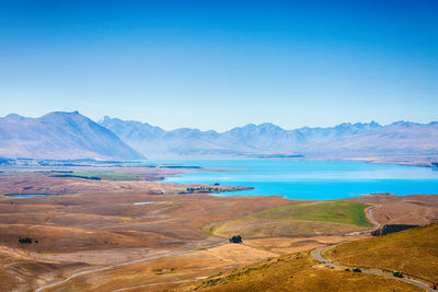 Scenic view of sea and mountains against blue sky