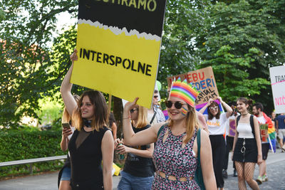 People standing on multi colored holding umbrella