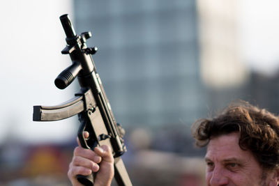 Close-up of man holding rifle