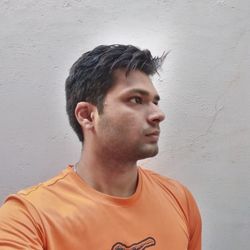 Portrait of young man looking away against wall