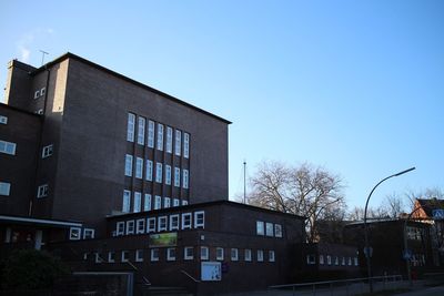 Low angle view of modern building against blue sky