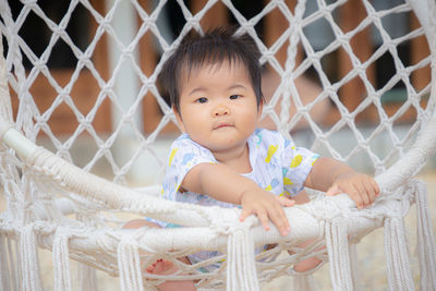 Portrait of cute baby girl behind fence