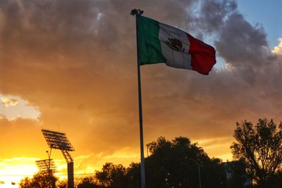 Low angle view of flag against sky at sunset