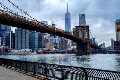 Low angle view of brooklyn bridge over sea in city