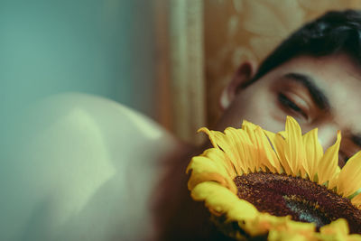 Close-up of man looking at sunflower