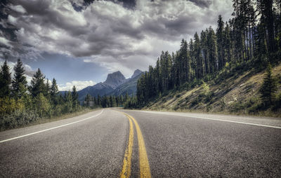 Road by mountains against sky