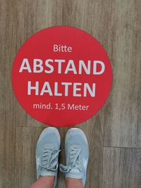 Low section of man standing on wooden sign