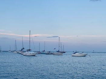 Sailboats in sea against sky