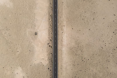 Aerial top down view of a road crossing a desert valley with sand in lanzarote, canary islands