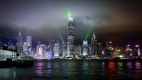 Two international finance center against sky in city at victoria harbor during night