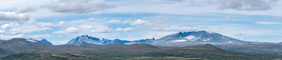 Scenic view of mountains against cloudy sky