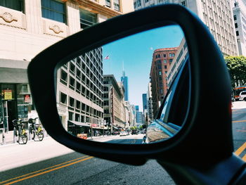 Reflection of city on side-view mirror