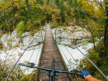 Gopro first person view mountain biking on narrow  suspension bridge above soca river, slovenia.
