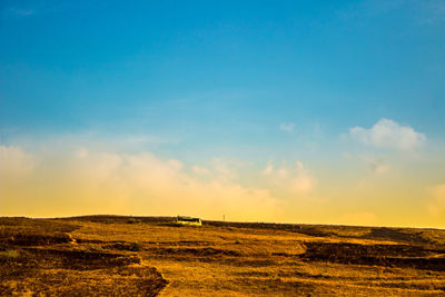 Scenic view of field against blue sky