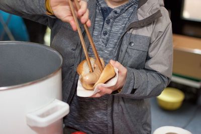 Midsection of boy eating hot dog